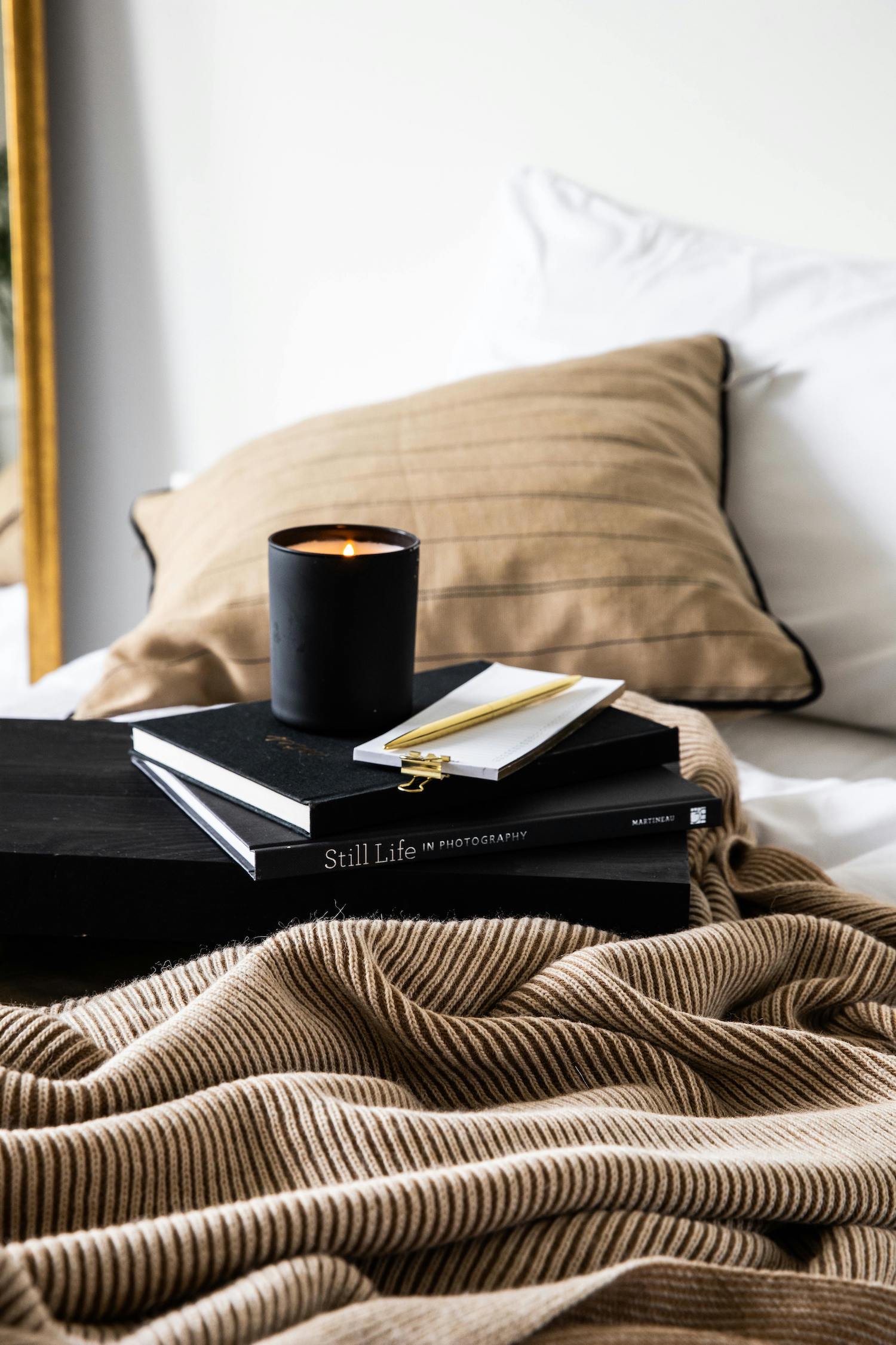 Candle and magazines on the bed