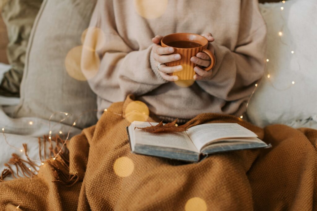 Woman holding a hot coffee and reading a book to learn introvert networking