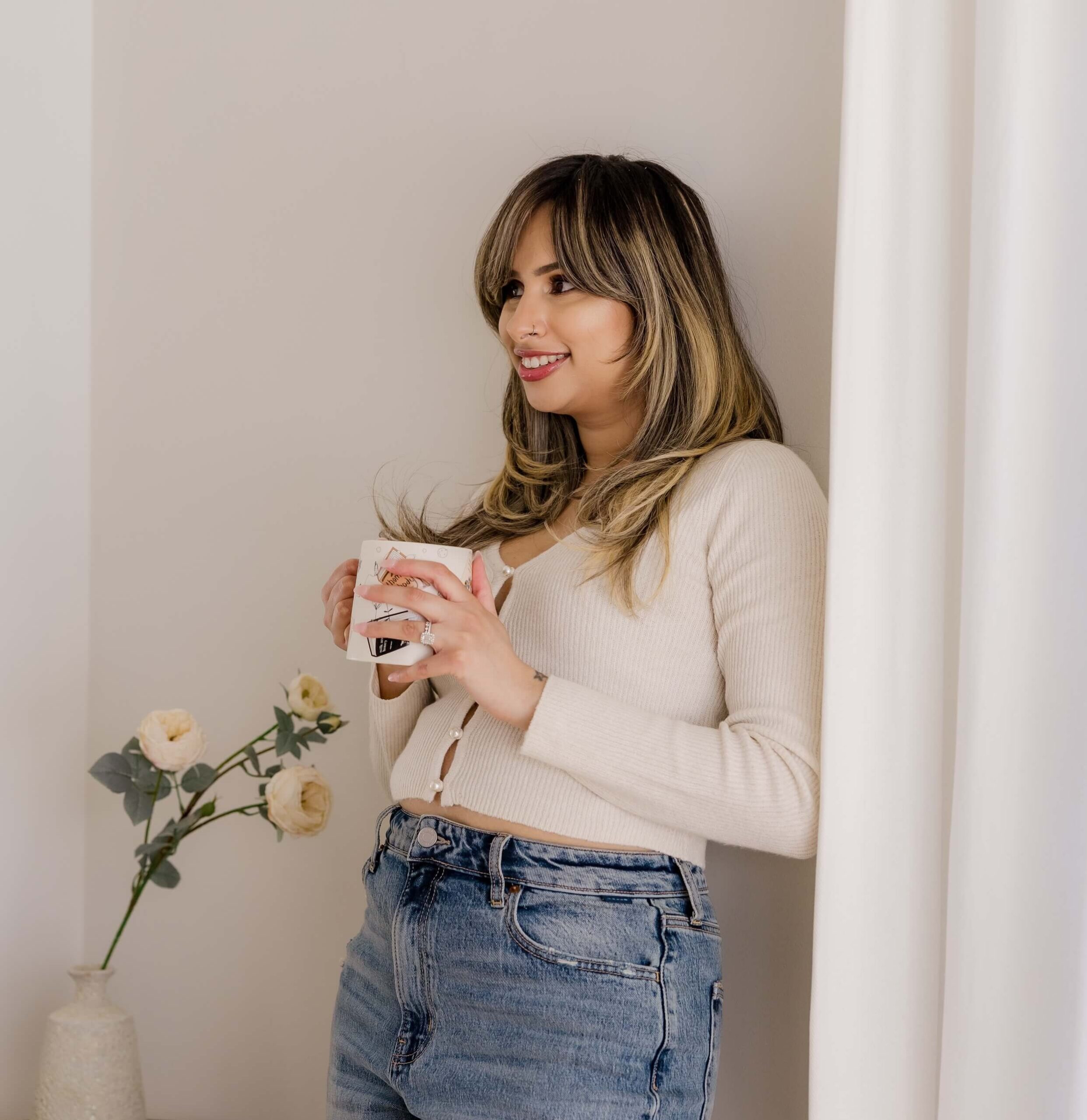 Website designer leaning against a wall holding coffee sharing my Website Development & Design Process