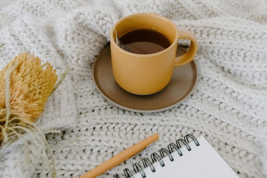 teacup and notebook on a blanket